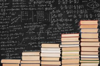 books stacked in front of chalkboard